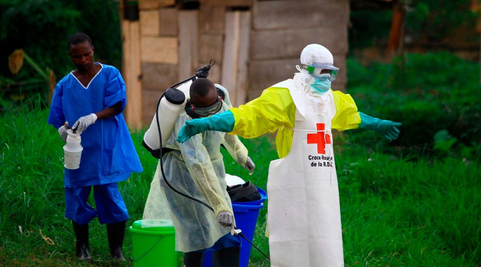 Un trabajador sanitario le rocía desinfectante a su colega tras trabajar en un centro de tratamiento del ébola en Beni, en el este de la República Democrática del Congo. AP/ARCHIVO
