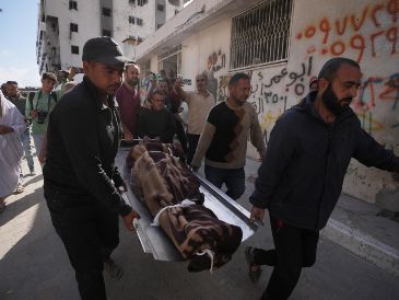 Palestinos cargan con el cuerpo de una persona fallecida en los ataques aéreos israelíes contra Izz al-Din al-Haddad, líder de las Brigadas Qassam de Hamás. AP/J. Alshrafi