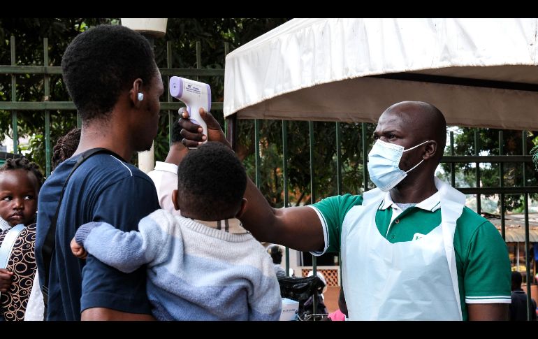 Un funcionario de salud utiliza un termómetro para tomar la temperatura a las personas frente al Hospital Musulmán de Kibuli, en Kampala, Uganda. AP/H. Nalwadda