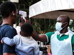 Un funcionario de salud utiliza un termómetro para tomar la temperatura a las personas frente al Hospital Musulmán de Kibuli, en Kampala, Uganda. AP/H. Nalwadda