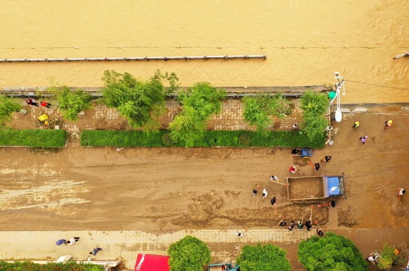 Vista aérea tomada con un dron de personas limpiando el lodo de una calle, en la ciudad de Duyun. XINHUA/X. Wei
