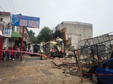 La pared se derrumbó justo sobre un camión de pasajeros y varias unidades que estaban estacionadas o circulando por la zona. SUN/ESPECIAL