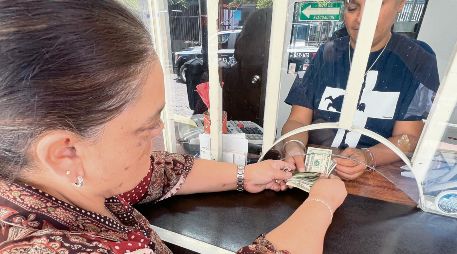 Una mujer cambia dólares enviados desde Estados Unidos, en medio de la incertidumbre por nuevas disposiciones económicas. EL INFORMADOR/ Archivo