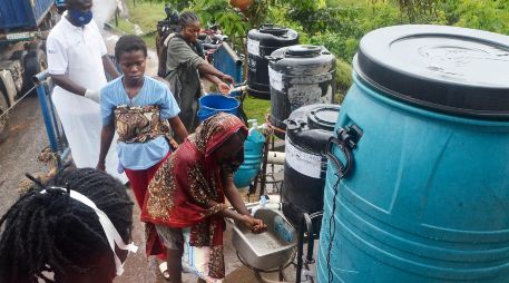 Imagen del 23 de mayo de 2026 de un oficial sanitario (i-atrás) indicando a los pasajeros que llegan que se laven las manos en el punto fronterizo, en Mpondwe, en el oeste de Uganda. Xinhua/N. Kajoba