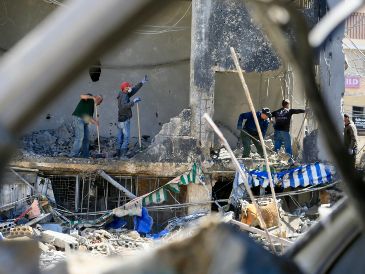 Varias personas limpian los escombros de un edificio destruido en los ataques aéreos israelíes, en Tiro, Líbano. XINHUA/A. Hashisho