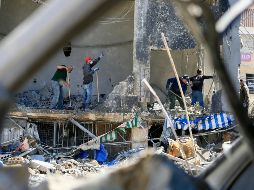 Varias personas limpian los escombros de un edificio destruido en los ataques aéreos israelíes, en Tiro, Líbano. XINHUA/A. Hashisho
