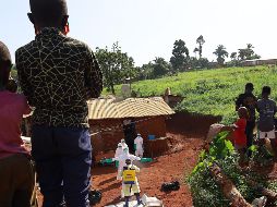 Trabajadores médicos portan trajes de protección mientras son desinfectados previo al entierro de una víctima de ébola, en Mongbwalu, en la provincia de Ituri, en el Congo. XINHUA/STR