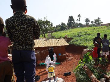 Trabajadores médicos portan trajes de protección mientras son desinfectados previo al entierro de una víctima de ébola, en Mongbwalu, en la provincia de Ituri, en el Congo. XINHUA/STR