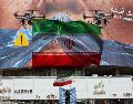 Un hombre con una bandera de Irán en Teherán debajo de un espectacular "antiEstados Unidos". EFE / EPA / ABEDIN TAHERKENAREH