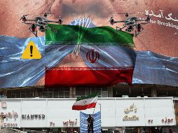 Un hombre con una bandera de Irán en Teherán debajo de un espectacular 