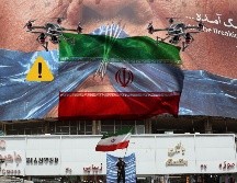 Un hombre con una bandera de Irán en Teherán debajo de un espectacular 