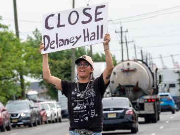 Una persona sostiene un cartel frente al centro de detención de inmigrantes Delaney Hall. La tensión continúa en la zona, donde inmigrantes mantienen por sexto día una huelga de hambre. EFE/A. Colmenares