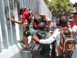 Personas ingresan por la fuerza a las oficinas de la Secretaría de Educación Pública durante una manifestación este miércoles, en la Ciudad de México. EFE/M. Hartz