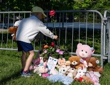 Un niño coloca flores en un altar improvisado en el Parc Ouellette, después de que una niña falleció cuando un castillo inflable fue arrastrado por el viento. AP/C. Muschi