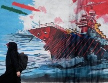 Una mujer pasa junto a un mural que muestra un portaaviones estadounidense bajo ataque en el centro de Teherán, Irán, el lunes 8 de junio de 2026. AP/Vahid Salemi