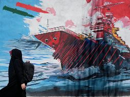 Una mujer pasa junto a un mural que muestra un portaaviones estadounidense bajo ataque en el centro de Teherán, Irán, el lunes 8 de junio de 2026. AP/Vahid Salemi