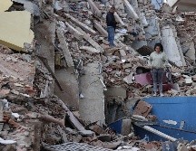 Residentes caminan entre los escombros de edificios derrumbados por los terremotos en la localidad de Catia La Mar, en el Estado costero de La Guaira, Venezuela, este jueves. EFE/ R. Pena