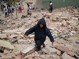 Un niño camina este jueves, entre los escombros de edificios afectados por los terremotos en La Guaira, Venezuela. EFE/ R. Peña