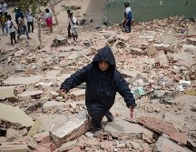 Un niño camina este jueves, entre los escombros de edificios afectados por los terremotos en La Guaira, Venezuela. EFE/ R. Peña