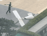 Fotografía cedida que muestra un integrante de la Policía de China frente a un fragmento de una aeronave en una vía próxima al edificio China Zun este viernes, en Pekin, China. EFE/ Cortesía