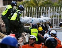 Rescatistas transportan un cuerpo recuperado de los escombros de un edificio derrumbado en Caracas, Venezuela. AP/P. Mattey
