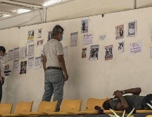Personas observan listas y fotografías de personas desaparecidas en los terremotos, este lunes, en un puerto en La Guaira, Venezuela. EFE/ Henry Chirinos