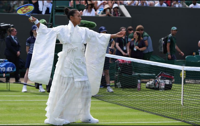 Naomi Osaka camina hacia el centro de la cancha vistiendo un kimono blanco antes de su partido de primera ronda ante la francesa Elsa Jacquemot. AP/M. Smiejkowska