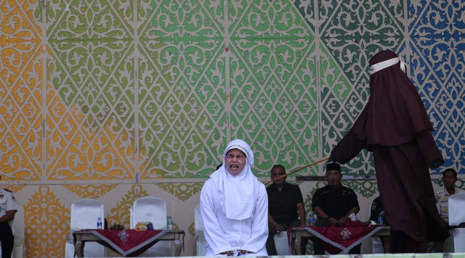 Una mujer de Aceh reacciona a los azotes durante un castigo público por violar la ley islámica en Banda Aceh, Indonesia, el 2 de julio de 2026. El Tribunal de la Sharia y la Fiscalía de Banda Aceh castigaron a los infractores con entre 10 y 30 azotes, incluyendo a una pareja que fue sorprendida besando a sus parejas en directo en la plataforma TikTok. EFE/H. SIMANJUNTAK