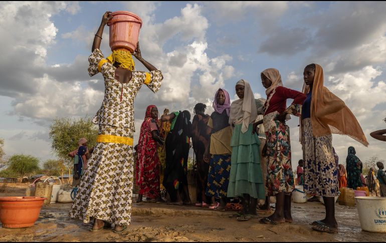 Mujeres y niños recogen agua al atardecer en el campamento de refugiados de Korsi en Birao, República Centroafricana, el 27 de marzo de 2026. AP/C. Kelly