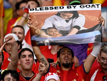Un aficionado español sostiene un cartel con la foto del joven Messi y Yamal cuando éste aún era un bebé. AFP/AFP/I. Fassbender