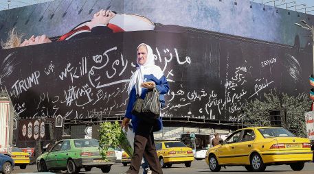 Un afiche monumental en Teherán mostrando a Donald Trump dentro de un féretro forma parte de la propaganda antiestadounidense que se puede observar en la capital iraní. AFP