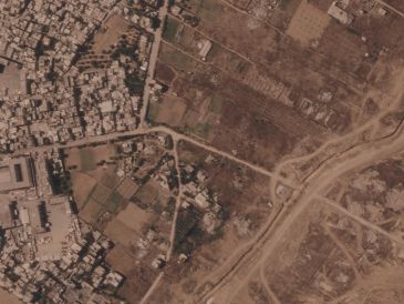Imagen por satélite que muestra un tramo de una barrera de tierra construida por el ejército israelí, desde el lado derecho de la imagen y hacia abajo, en el centro de la Franja de Gaza, el 1 de julio de 2026. A la izquierda se ve el campo de refugiados de Maghazi, y al otro lado casas demolidas por el ejército. AP/Planet Labs PBC via AP)