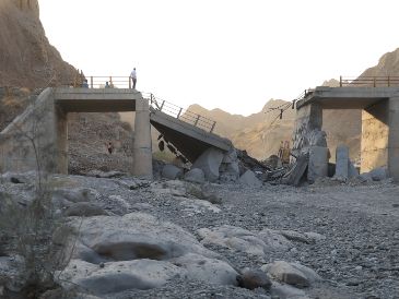 Gente de pie en un puente destruido tras un ataque en lap provincia de Hormozgan, en el sur de Irán. AP/A. Khorgooi