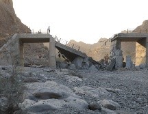 Gente de pie en un puente destruido tras un ataque en lap provincia de Hormozgan, en el sur de Irán. AP/A. Khorgooi