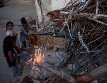 Personas encienden velas durante un homenaje a las víctimas por los terremotos del pasado 24 de junio, este viernes en Catia La Mar. EFE/R. Peña