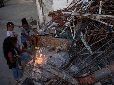 Personas encienden velas durante un homenaje a las víctimas por los terremotos del pasado 24 de junio, este viernes en Catia La Mar. EFE/R. Peña