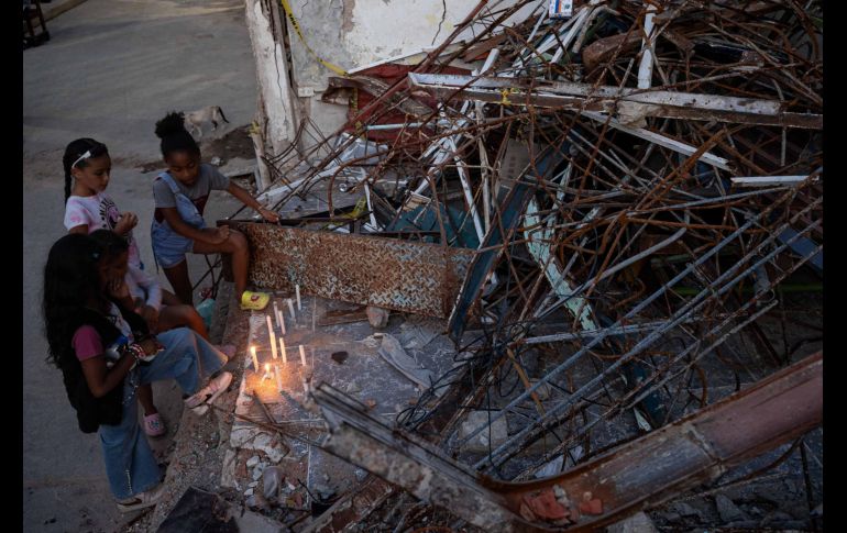 Personas encienden velas durante un homenaje a las víctimas por los terremotos del pasado 24 de junio, este viernes en Catia La Mar. EFE/R. Peña