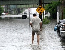 Una persona camina a través de una inundación en Central Avenue cerca de la Interestatal 90. AP/W. Waldron