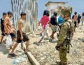 Un soldado español verifica que los migrantes que irrumpieron en Ceuta vuelvan al lado marroquí. EFE