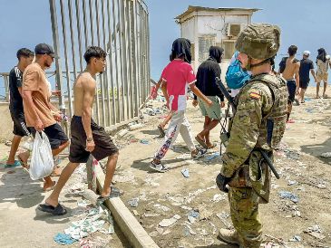 Un soldado español verifica que los migrantes que irrumpieron en Ceuta vuelvan al lado marroquí. EFE