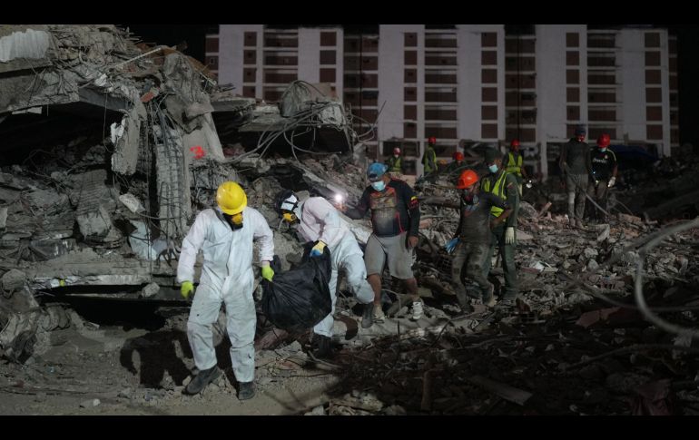 Unas personas transportan un cadáver rescatado de un edificio que se derrumbó a causa de los terremotos en La Guaira, Venezuela. AP/A. Cubillos