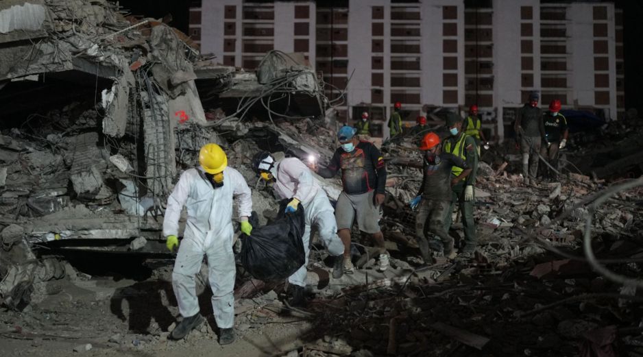 Unas personas transportan un cadáver rescatado de un edificio que se derrumbó a causa de los terremotos en La Guaira, Venezuela. AP/A. Cubillos