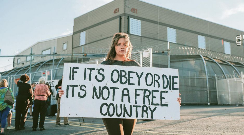 La pancarta que la manifestante sostiene expresa “si debemos elegir entre obedecer o morir, no es un país libre”. EFE