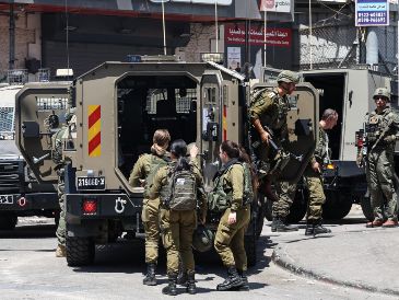 Vehículos del IDF, en la entrada del campo de refugiados de Qalandia, frente a la sede de la UNRWA, en Cisjordania ocupada. EFE/M. Gibelli