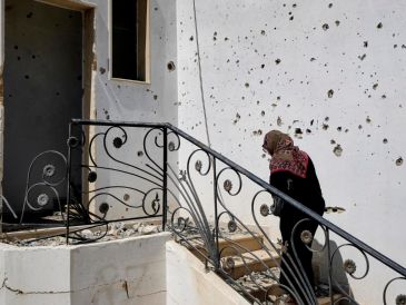 Ihsan Yaghi, de 60 años y vecina de la localidad de Zawtar al Gharbiya, entra en su vivienda tras el paso del ejército israelí por la localidad de Zawtar Al Gharbiya, al sur del Líbano. EFE/ E. Gutiérrez