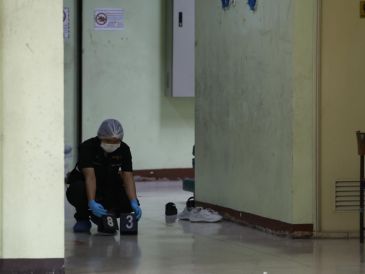 Un policía recabando pruebas tras el tiroteo en una escuela de Tailandia. EFE/R. YONGRIT