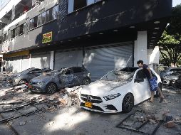 Un hombre observa un vehículo afectado tras un fuerte temblor este lunes, en Cali, Colombia. EFE/ Ernesto Guzmán