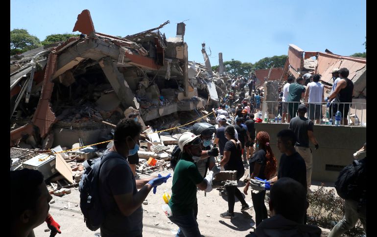 Integrantes del cuerpo de Bomberos de Cali y civiles buscan entre los escombros de edificaciones colapsadas por el terremoto de magnitud 7.4 que sacudió esta mañana el país, este lunes en Cali (Colombia). EFE / E. Guzmán