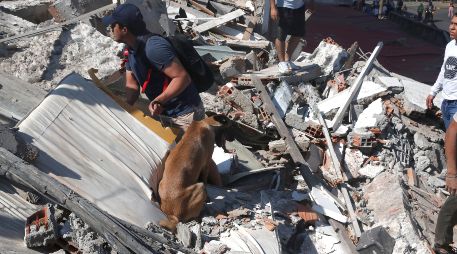 Personas caminan sobre los escombros de un edificio colapsado este lunes, en Cali, Colombia. EFE/ E. Guzmán