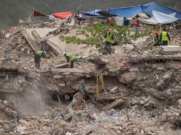 Personas remueven escombros de un edificio colapsado por los terremotos del 24 junio, este domingo en La Guaira, Venezuela. EFE/ R. Peña R